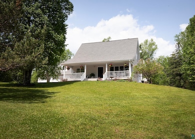 View of front of house with covered porch and a front lawn