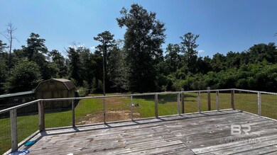 Deck featuring a lawn and a storage unit