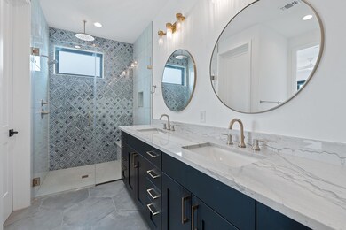 Bathroom with visible vents, a sink, a stall show