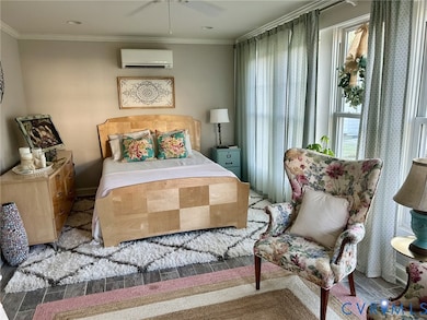 Bedroom with ornamental molding, wood finish floors, a ceiling fan, and a wall mounted air conditioner