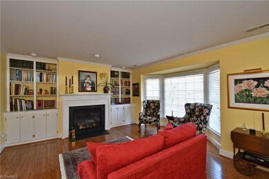 Living room with fireplace, built-ins and bay window.