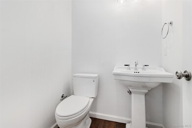 Bathroom featuring baseboards and dark wood finished floors