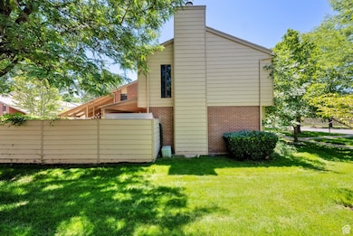 Back of house featuring brick siding and a chimney