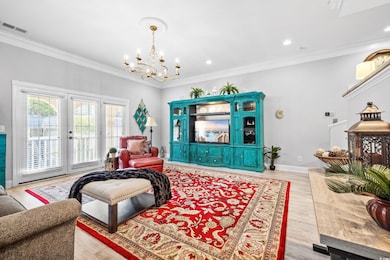 Living room with a notable chandelier, light wood-