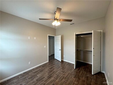 Unfurnished bedroom featuring dark wood-style floors, baseboards, a closet, and ceiling fan