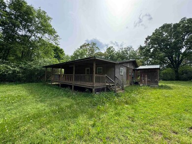 Back of property with a yard, a deck, a shed, and 