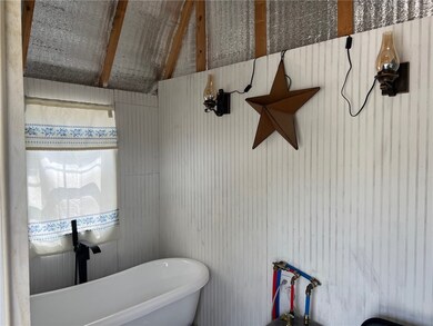Bath house with tub, tankless water heater and win