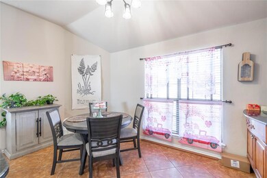 Tiled dining room featuring an inviting chandelier