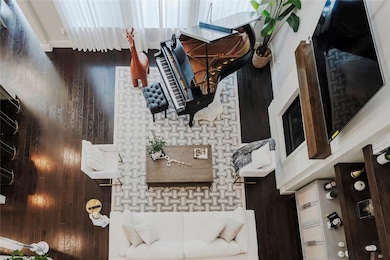 Living room with hardwood / wood-style floors and a high ceiling