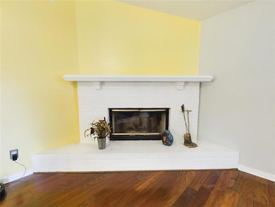 Detailed view of wood finished floors and a brick fireplace