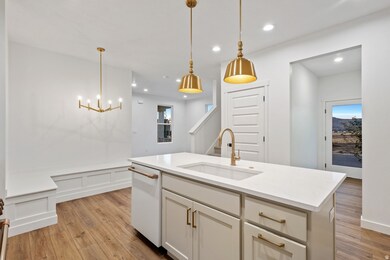Kitchen featuring GE Cafe appliances tasteful backsplash, light wood finished floors, and decorative light fixtures