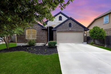 French country home featuring brick siding, a gar