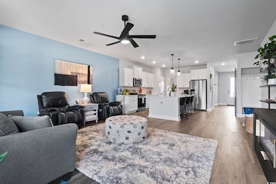 Living room with recessed lighting, dark wood-style flooring, and a ceiling fan
