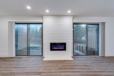 Unfurnished living room with plenty of natural light, wood finished floors, and a fireplace