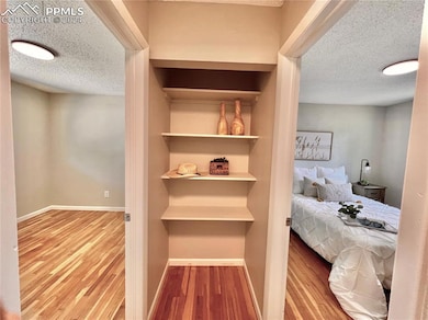 Bedroom featuring a textured ceiling and hardwood 