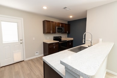 Ample countertop space and a deep kitchen sink with a retractable, extendable faucet for easy cleanup.