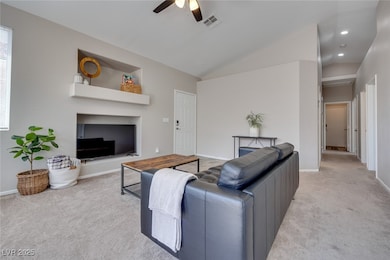 Living room with light carpet, a ceiling fan, loft