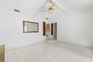 Tiled spare room with vaulted ceiling with beams and ceiling fan