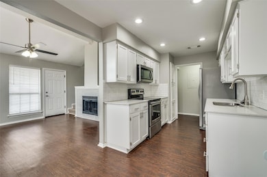 Kitchen with a sink, white cabinets, appliances wi