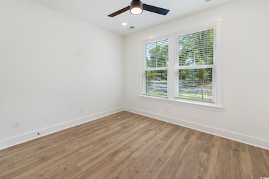 Spare room featuring wood finished floors and a ceiling fan