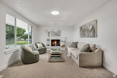 Carpeted living room featuring baseboards and a brick fireplace