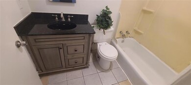 Bathroom with toilet, tile patterned floors, vanity, and shower / bath combination
