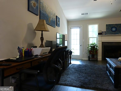 This inviting and generously sized family room offers versatile functionality, making it an ideal space for a home office setup or a comfortable dining area complete with a table and chairs, perfect for family meals and gatherings.