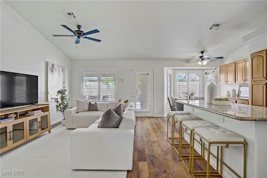 Living area with a ceiling fan, vaulted ceiling, p