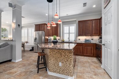 Here's a sneak peek at the show-stopping kitchen which has plenty of natural light, rich wood cabinetry and upgraded lighting pendants.