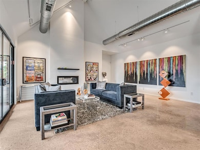 Living room with track lighting, high vaulted ceiling, and baseboards