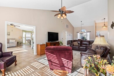 Tiled living room featuring ceiling fan with notab