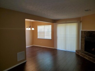 Unfurnished living room with a chandelier, a fireplace, dark wood-type flooring, and a textured ceiling