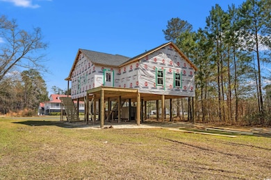 Back of property featuring stairs, a carport, a la