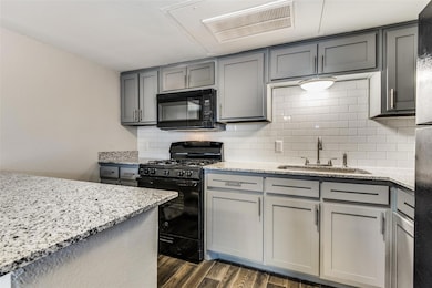 Kitchen with black appliances, gray cabinets, dark