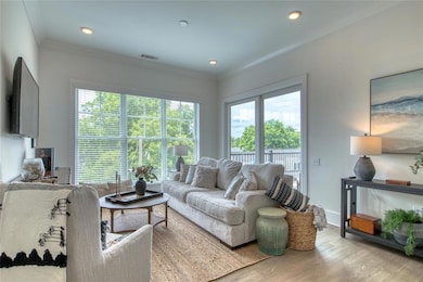 Living room featuring light hardwood / wood-style flooring and ornamental molding