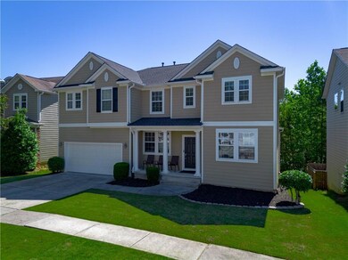 View of front of property with a porch, driveway, a front lawn, and an attached garage