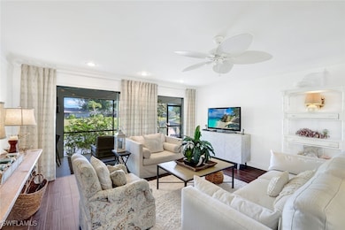 Living room with crown molding, ceiling fan, and d