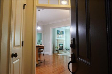 Hall with hardwood flooring and ornamental molding