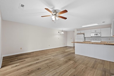 Kitchen featuring a peninsula, white appliances, w