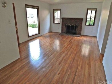 Living room with gleaming floors and brick firepla