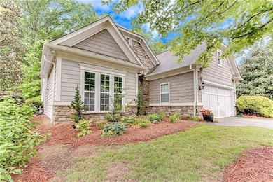View of front of home featuring stone siding, driv
