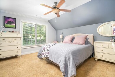 Carpeted bedroom featuring vaulted ceiling, ceiling fan, and ornamental molding