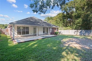 Back of property featuring a fenced backyard, roof with shingles, and a patio