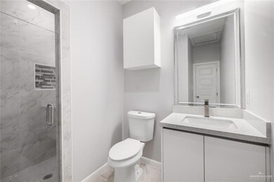 Bathroom with vanity, an enclosed shower, and toilet