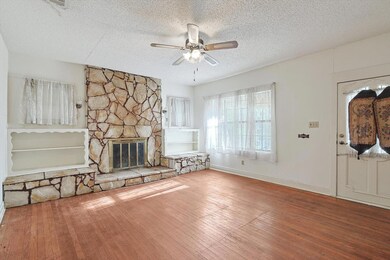 Unfurnished living room featuring a stone fireplac