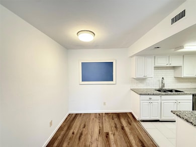 Kitchen featuring a sink, light stone countertops