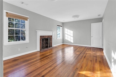 Unfurnished living room featuring hardwood / wood-style flooring and a fireplace
