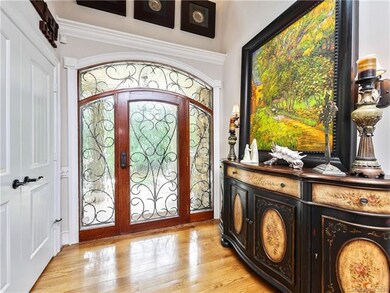 Foyer has custom entry doors with iron work