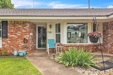 Entrance to property featuring brick siding and a shingled roof