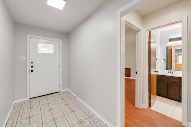 Entrance foyer with baseboards and light wood-sty